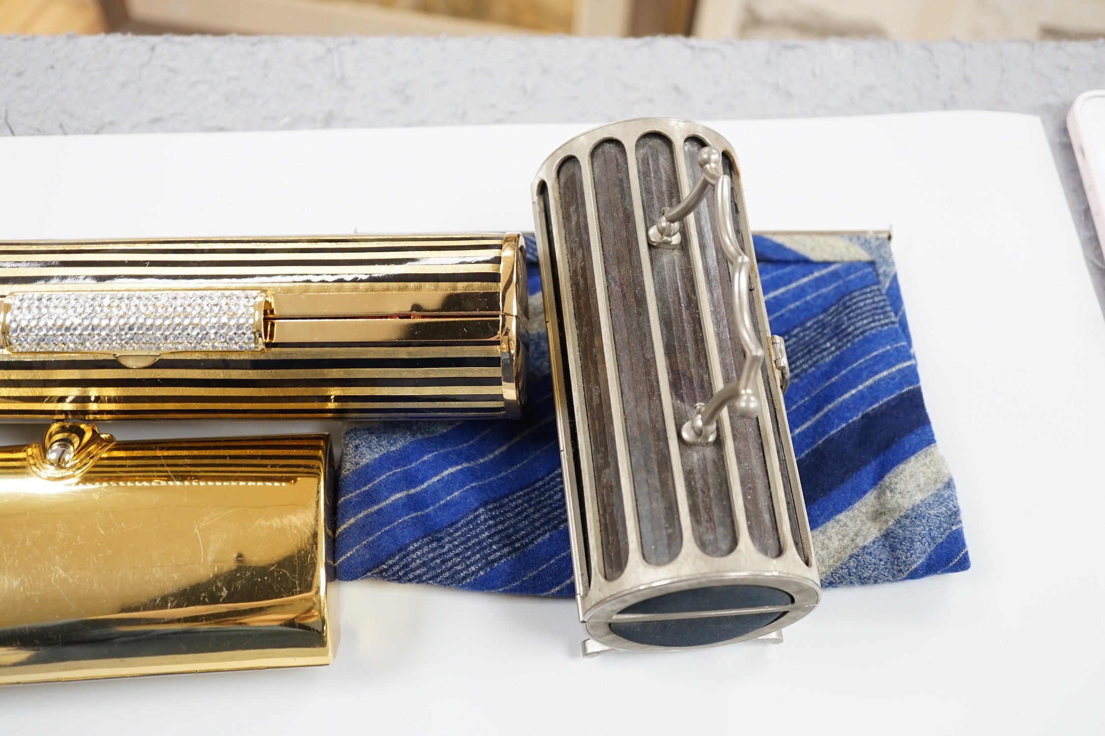 Two 1960's gilt metal ladies evening bags, a metal and wooden bag, a 1950's plastic and fabric bag possibly American, a 1930's faux crocodile clutch bag and a 1930's stripe clutch bag